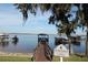 Picturesque lake view with a wooden dock and covered gazebo, enhanced by tranquil waters and boat lifts at 292 Nautica Mile Dr, Clermont, FL 34711