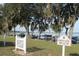 Charming private beach entrance with white picket fence and boat docks in the background at 292 Nautica Mile Dr, Clermont, FL 34711