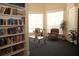 Cozy reading area with a full bookcase, comfortable seating, and ample natural light from large windows at 292 Nautica Mile Dr, Clermont, FL 34711