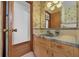 Bathroom featuring a classic vanity, mirror, and tiling with an adjacent doorway and access to other spaces at 2928 Delaney St, Orlando, FL 32806