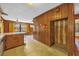 View of the kitchen with wood walls and breakfast bar, showing connection to other rooms at 2928 Delaney St, Orlando, FL 32806