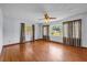Bright living room featuring hardwood floors, large windows, and a ceiling fan, offering ample natural light at 2928 Delaney St, Orlando, FL 32806