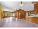 Open-concept living area with wood paneling and a view into the kitchen at 2928 Delaney St, Orlando, FL 32806