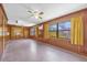 View of a spacious living room with wood walls, bright windows, and yellow curtains at 2928 Delaney St, Orlando, FL 32806