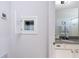 This bathroom has light colored walls with a large vanity and mirror adjacent to an open cabinet at 3002 Bethpage Loop, Mount Dora, FL 32757