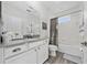Well-lit bathroom with a shower/tub combo, white cabinets, a stone countertop, and a framed mirror at 3002 Bethpage Loop, Mount Dora, FL 32757