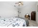 Bright bedroom featuring a queen-sized bed, a ceiling fan, soft carpet, and a view to the hallway at 3002 Bethpage Loop, Mount Dora, FL 32757