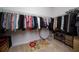 A walk-in closet with clothes hanging from the rods and shelves for shoes at 3002 Bethpage Loop, Mount Dora, FL 32757