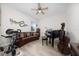 Cozy living room featuring neutral paint, ceiling fan, window, piano, and comfortable seating at 3002 Bethpage Loop, Mount Dora, FL 32757