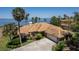 Aerial view of home with barrel tile roof, lush landscaping and waterfront views at 301 Waterwood Dr, Yalaha, FL 34797