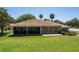 Charming home with an inviting screened lanai, brick exterior, and lush green lawn at 301 Waterwood Dr, Yalaha, FL 34797