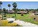 Lakeside home featuring a screened lanai, brick detail, and expansive green lawn at 301 Waterwood Dr, Yalaha, FL 34797