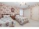 Charming bedroom with twin beds, floral wallpaper, and a ceiling fan for added comfort at 301 Waterwood Dr, Yalaha, FL 34797