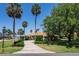 Inviting home with manicured shrubs and a gracefully curved driveway surrounded by tall palm trees at 301 Waterwood Dr, Yalaha, FL 34797