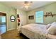 Comfortable bedroom featuring light green walls, a ceiling fan, and a cozy bed with a floral quilt at 30554 Quince Ave, Eustis, FL 32736