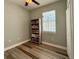 Cozy bedroom with wood floors, ceiling fan, and a bookshelf full of books at 30554 Quince Ave, Eustis, FL 32736