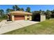 Large concrete driveway leading to a two-car garage and metal carport at 30554 Quince Ave, Eustis, FL 32736