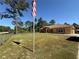 Single-story home with a well-manicured lawn and a classic American flag at 30554 Quince Ave, Eustis, FL 32736