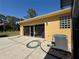 Exterior view of a beige garage with a screened-in door and an air conditioning unit at 30554 Quince Ave, Eustis, FL 32736