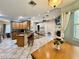 Bright, open living area with a fireplace, ceiling fan, and a kitchen area with bar seating at 30554 Quince Ave, Eustis, FL 32736