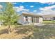 A view of the backyard featuring a small patio and lush grassy area under a partly cloudy sky at 31799 Broadwater Ave, Leesburg, FL 34748