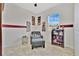 Cozy bedroom featuring a comfortable armchair with ottoman, complemented by charming decorations and bright natural light at 31799 Broadwater Ave, Leesburg, FL 34748