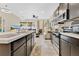Modern kitchen featuring dark cabinetry, stainless appliances, and open layout into the living area at 31799 Broadwater Ave, Leesburg, FL 34748