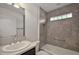 Modern bathroom featuring a tiled shower-tub combo, vanity, and sleek fixtures at 3305 Dzuro Dr, Oxford, FL 34484