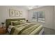 Comfortable bedroom with a green bedspread, modern art, and lots of natural light at 3305 Dzuro Dr, Oxford, FL 34484