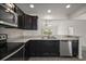 Spacious kitchen with stainless steel appliances, dark cabinets, and a view into a bright dining area at 3305 Dzuro Dr, Oxford, FL 34484