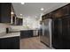 Modern kitchen with stainless steel appliances, dark cabinets, and ample counter space for cooking at 3305 Dzuro Dr, Oxford, FL 34484