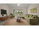 Inviting living room with a large sectional sofa and view of the outdoors at 3305 Dzuro Dr, Oxford, FL 34484