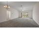 Spacious living room featuring vaulted ceilings, neutral walls, and sliding glass doors to outside at 3305 Dzuro Dr, Oxford, FL 34484