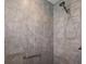 Modern tiled shower with a rainfall showerhead and a grab bar for accessibility at 3305 Dzuro Dr, Oxford, FL 34484