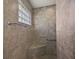 Tiled shower with a built-in seat and glass block window for natural light at 3305 Dzuro Dr, Oxford, FL 34484