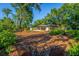 Large backyard with mature trees, mulch, and landscaping featuring a screened in porch at 333 Stanley Bell Dr, Mount Dora, FL 32757