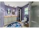 Bathroom with dual sinks, vanity, custom light fixtures, walk in shower, and modern commode at 333 Stanley Bell Dr, Mount Dora, FL 32757
