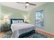 Bedroom with light-green walls features a Queen bed, lamps on side tables, and a ceiling fan at 333 Stanley Bell Dr, Mount Dora, FL 32757