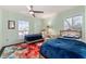 Bright bedroom featuring two twin beds, ceiling fan, and a colorful floral area rug at 333 Stanley Bell Dr, Mount Dora, FL 32757