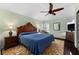 Bedroom with a ceiling fan, bedside table with lamp, and a large decorative wood headboard at 333 Stanley Bell Dr, Mount Dora, FL 32757