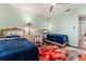 Bright bedroom featuring two twin beds, ceiling fan, and a colorful floral area rug at 333 Stanley Bell Dr, Mount Dora, FL 32757