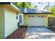 Charming yellow home featuring a two-car garage and bay window, set against a backdrop of greenery at 333 Stanley Bell Dr, Mount Dora, FL 32757