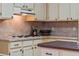 Compact kitchen features a cooktop with range hood and adjacent countertops at 333 Stanley Bell Dr, Mount Dora, FL 32757