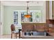 Charming kitchen sink beneath bright bay window with decorative hanging light fixture at 333 Stanley Bell Dr, Mount Dora, FL 32757