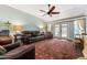 Bright living room featuring a high ceiling, ceiling fan, and a comfortable leather sofa at 333 Stanley Bell Dr, Mount Dora, FL 32757