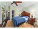 Bedroom showcasing hardwood floors, an ornate headboard, and a view of an adjacent bathroom and walk-in closet at 333 Stanley Bell Dr, Mount Dora, FL 32757