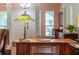 Office area showcasing a wood desk and unique Tiffany style lamp, leading to the entry door at 333 Stanley Bell Dr, Mount Dora, FL 32757