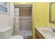 A practical bathroom features a shower with a tiled surround and a shower curtain with a tropical print at 33801 Picciola Dr, Fruitland Park, FL 34731