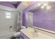 An amethyst-themed bathroom with a tub-shower combo, large mirror, and decorative chandelier lighting at 33801 Picciola Dr, Fruitland Park, FL 34731