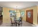 Dining area with glass table, wooden chairs, chandelier and view to front yard at 33801 Picciola Dr, Fruitland Park, FL 34731